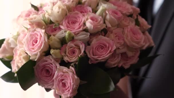 Beau bouquet de roses multicolores entre les mains des hommes. homme en costume va à un rendez-vous avec de belles fleurs. gros plan — Video