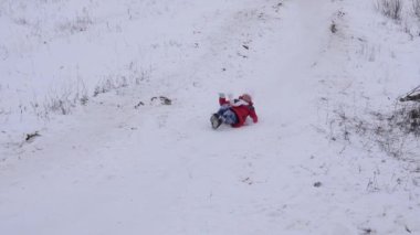 Mutlu kız kış ve gülümser üzerinde beyaz kar kızakta karlı dağdan alır. Noel tatili. Ağır çekim