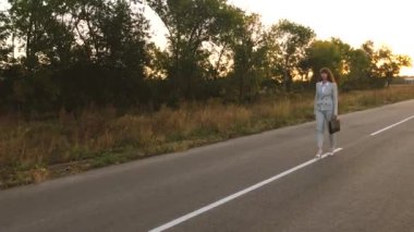 iş kadını siyah evrak çantası ile asfalt beyaz markings ile yürür
