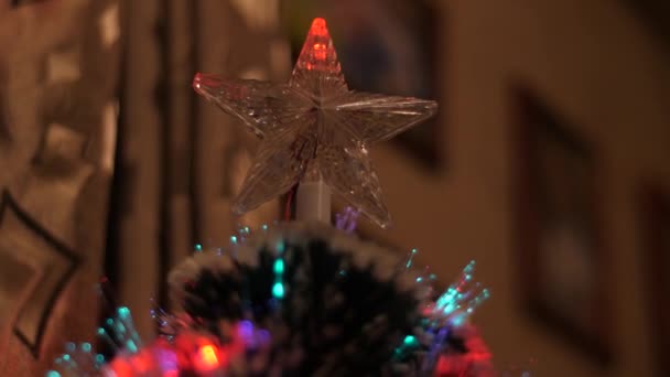 Jul stjärna lyser med färgade lighchristmas träd i rummet skiner med blå, röda lampor. — Stockvideo