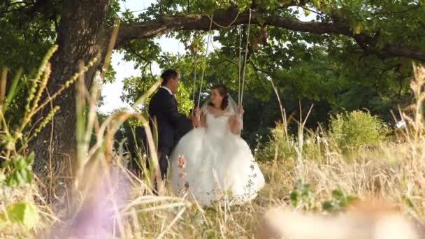 Mannen Kostym Och Kvinnan Vit Brudklänning Ligger Glad Ridning Swing — Stockvideo