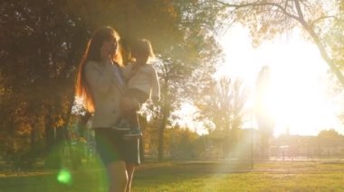 Anne çocuk silah ve cep telefonu üzerinde görüşmeler taşır. Aile akşam şehir parkta yürüyor..