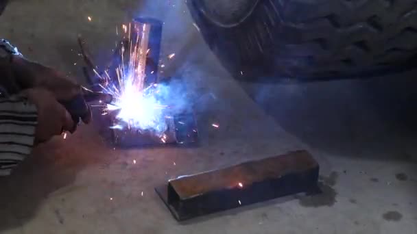 Svetsare svetsning stål och järn. smält gnistor av metall i olika riktningar. koncept: manuellt arbete, industri, svetsare. — Stockvideo