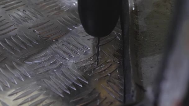 Trabajador perfora agujero en hoja de aluminio. perforación de metal brillante con un taladro eléctrico. Primer plano. trabajos de reparación en el taller . — Vídeos de Stock