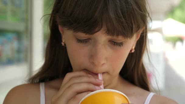 아름 다운 여 아 밀 짚의 칵테일 마시는 도시 주위를 산책에 대 한 웃 고. 클로즈업입니다. 십 대 소녀는 공원에서 시원한 음료를 마시는. — 비디오