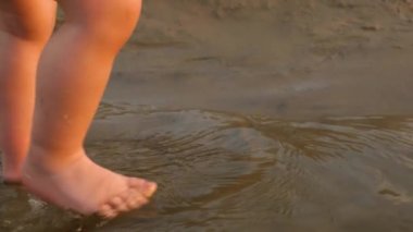 su plajda, ağır çekim bacaklar çocuğun devam