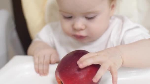 Мальчик кусает яблоко с первыми молочными зубами . — стоковое видео