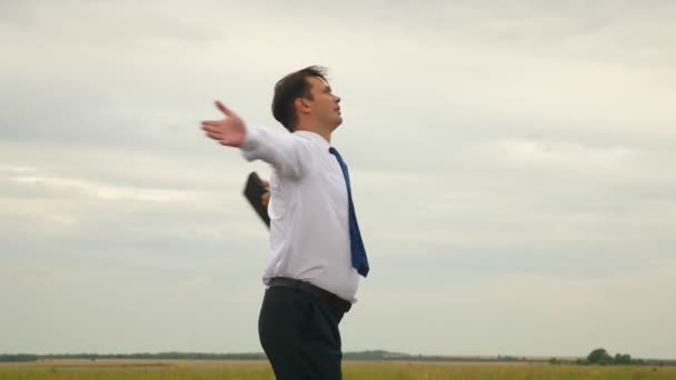 Zakenman in wit overhemd en stropdas met werkmap in de wervelwind van zijn hand tijdens de vlucht tegen de achtergrond van de donkere wolken — Stockvideo