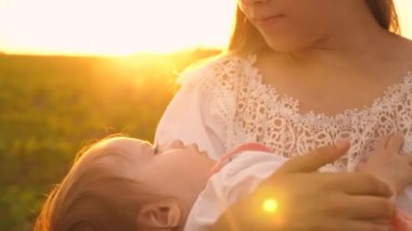 Bebek günbatımı altın ışınları annesinin kollarında uyuya kalır. Ağır çekim