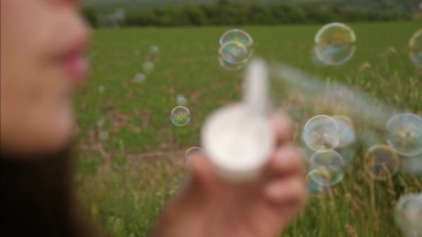 Dívka je transparentní mýdlové bubliny a směje se fouká. Zpomalený pohyb. Closeup — Stock video