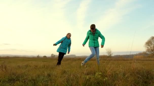 Bambini e mamma giocano a calcio sul campo. Famiglia che gioca con bambino piccolo da palla da bambini in un parco. Rallentatore . — Video Stock