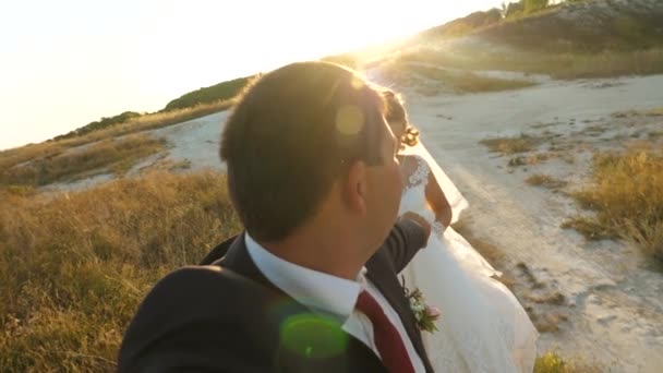 Couple in love runs hand in hand on a summer evening in park. happy bride and groom run on white road. happy family concept. Slow motion. — Stock Video