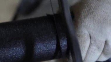 Tesisatçı beyaz koruyucu eldiven testere siyah tüp demir testeresi ile. yakın çekim