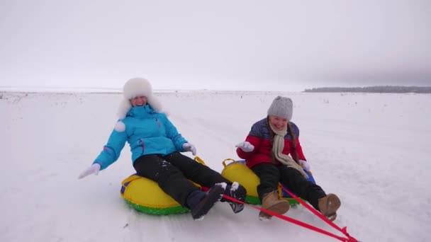 Szczęśliwe dzieci Łyżwy Mama zimą w śniegu i grać śnieżkami. Mama i córka się śmiać i cieszyć się. Rodzina grać w winter park podczas świąt Bożego Narodzenia. Zwolnionym tempie — Wideo stockowe