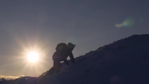 Turista hace subir a la cima en el fondo del hermoso cielo. Escalador sube montaña nevada en rayos de sol brillante. hombre se mueve a la cima de su éxito . — Vídeos de Stock