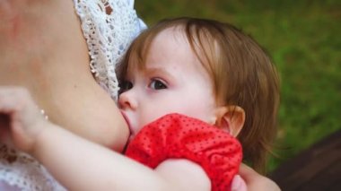 Şehir Parkı anne breastfeeds bebek. Anne ve çocuk. Anne sütü. Yakın çekim