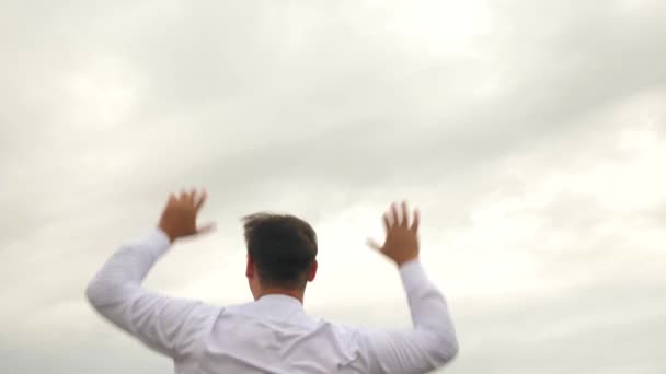 Деловой человек в белой рубашке рад, что его повысили на фоне голубого неба — стоковое видео