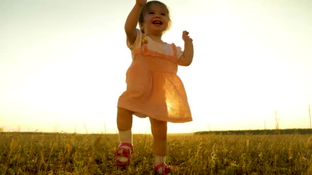 小さな子供は 笑いと笑顔の夏の公園の最初のステップです 赤ちゃんは 太陽の光に照らされて スローモーション — ストック動画