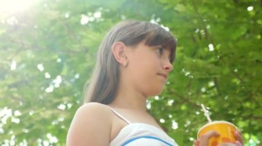 Kız sıcak gün güneş parlamayı saman serin kokteyl içer. Yakın çekim