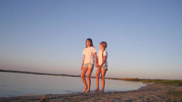 Tieners meisjes lopen langs strand en glimlach. — Stockfoto