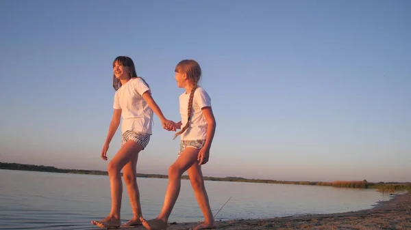 Tieners meisjes lopen langs strand en glimlach. — Stockfoto