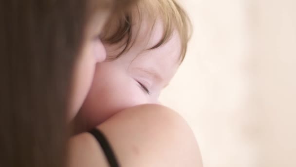 Ung mamma skakar sitt lilla barn att sova. — Stockvideo