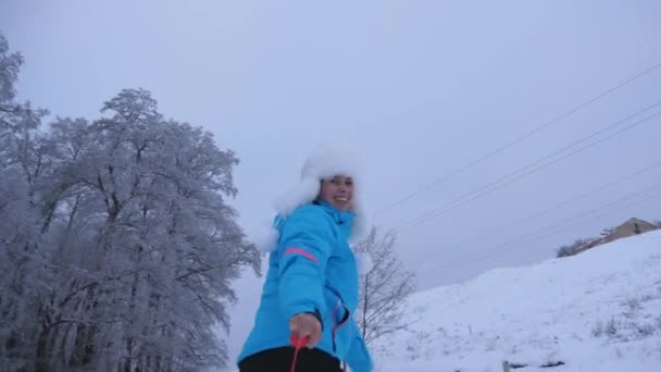Bonne fille d'hiver joue avec la soucoupe de neige sur la neige blanche et rit. Femme en vacances sourit et joue. Vacances de Noël — Video