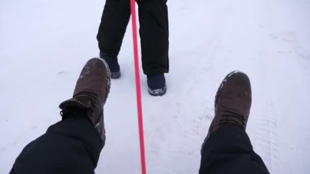 Ung familj att ha kul på släde i snöig vinterdag. Människor rida snö tefat. Närbild. Jul — Stockvideo