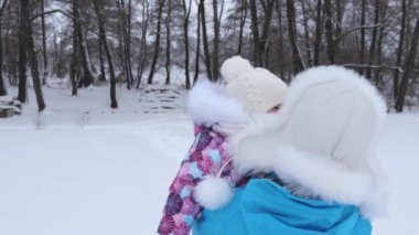 Bebek benim annem ellerinde kışın soğuk gününde beyaz karda yürür. Doğada yürüyüşe Çocuk annesiyle. Noel tatili