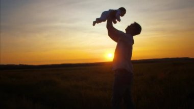Baba Çocuk altın güneş batımında atar. Ağır çekim.