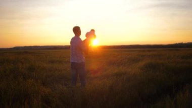 Baba ile bebek günbatımında uçakta oynar. Ağır çekim.