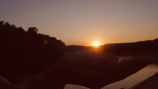 Solen i handflatorna av barn, röd solnedgång över floden — Stockvideo