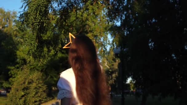 Menina soprando belas bolhas de sabão grandes no parque da cidade e sorrindo. Movimento lento . — Vídeo de Stock