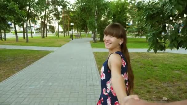 Girl leads man by hand on warm summer evening day and smiles. Happy woman runs through park and laughs — Stock Video