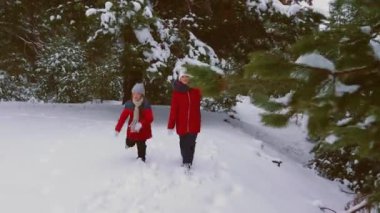 Mutlu çocuk karlı çam ormanı ve kahkaha ile çalıştırın. Oynayan gençler iğne yapraklı Park'ta görüşürüz. Noel