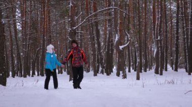 Sevgi dolu çift karlı kış orman ve gülmek yürür. Kadın ve erkek birlikte parkta kış aylarında vakit. Noel hafta sonu