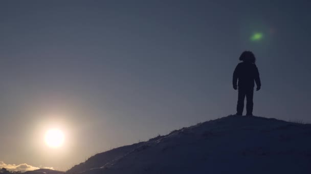 Touriste homme se tient haut sur la montagne pendant l'éblouissement du coucher du soleil au pôle nord. Conditions naturelles froides en voyage. Vaincre les sommets par l'alpiniste — Video