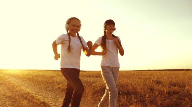 Genç kızlar günbatımında eğitimi ve müzik. kırsal kesimde koşu spor yaparken Kulaklığımda genç kız.
