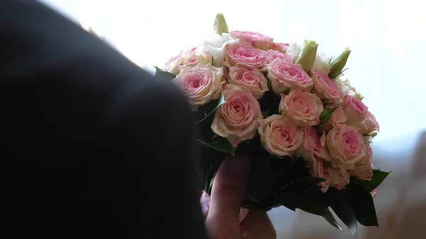 Mazzo di rose multicolori nelle mani di un uomo . — Foto Stock