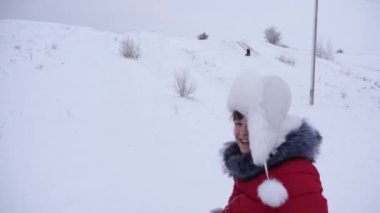 Mutlu kız kar daire ve kahkaha ile sürmek. Kışın halletme ve gülen çocuk. Dağ tatil. Noel tatili