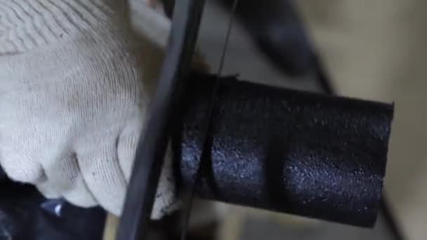 Instalador en guantes protectores blancos sierra tubo negro con sierra. Un hombre trabajando en el garaje. primer plano — Vídeo de stock