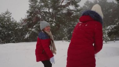 Mutlu çocuklar kartopu çam ormanı ve gülmek oynar. Neşeli genç kız kar ile kışın çam parkta oynamak. Noel