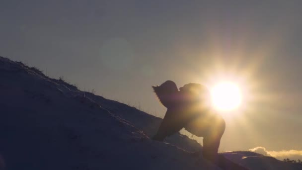 O homem alpinista sobe lentamente da montanha nevada para não cair. Extremas caminhadas turísticas nas montanhas. Viajante de caminhada. Conquista de picos pelo homem — Vídeo de Stock