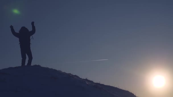 振って高雪に覆われた山の頂上を征服した男の手し、夕暮れ時の勝利に喜ぶ。旅行するとき冷たい自然条件。クライマーによってピークを征服します。勇敢な極端な上昇 — ストック動画