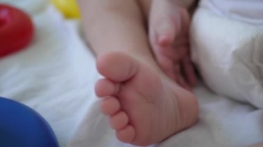 Bebek ayak yakın çekim. Çocuk bezli oyuncaklarla çalış