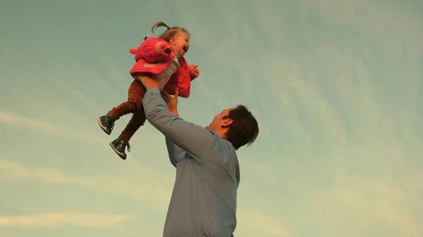 爸爸把一个孩子扔到天上去了父亲把孩子扔向天空。幸福的家庭理念。爸爸和孩子一起玩 — 图库照片