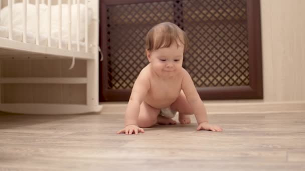 Criança feliz aprende a rastejar no chão na sala das crianças — Vídeo de Stock