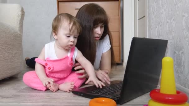 Fiatal anya és a gyermek egy számítógépen dolgozik — Stock videók