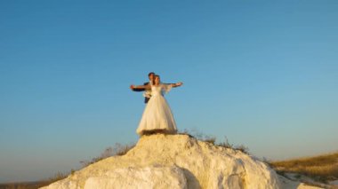 Mutlu gelin ve damat sarılmak ve ellerini mavi Berrak gökyüzü karşı düzleme ve gülümseyen uçmak. Çiftler için romantik yolculuk. Çiftler seyahat