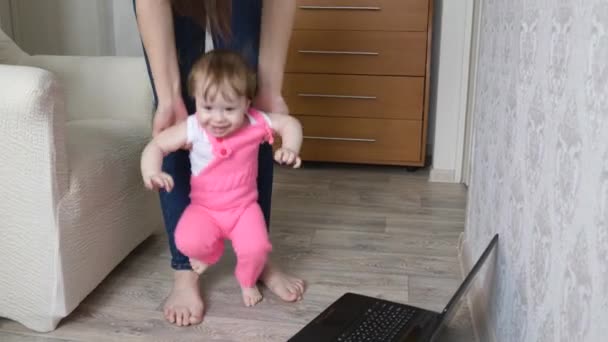 El bebé juega con mamá en la guardería. Bebé feliz con los padres saltando y sonriendo en las manos de mamá — Vídeo de stock